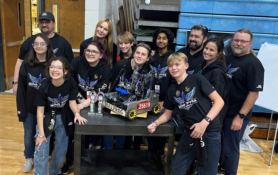 FTC 25619 Nova Pyra team members surrounding their robot 'Bullfrog' with their trophies after their successes at the 2024-2025 FTC LA Qualifier 1 at Hammond Crossroads